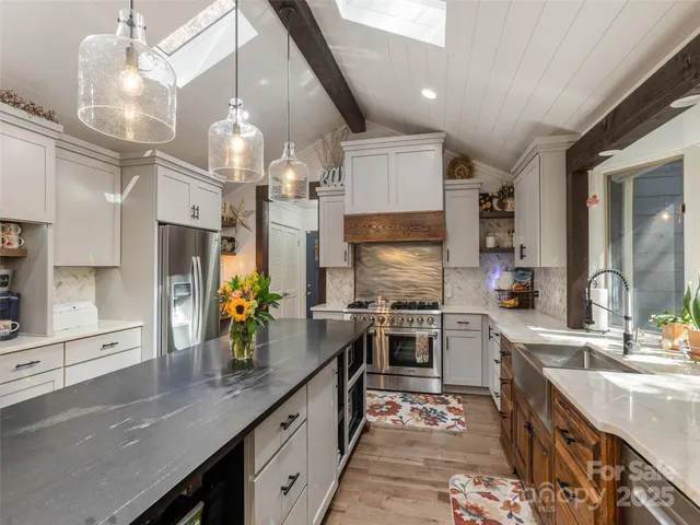 a kitchen with stainless steel appliances a sink stove and refrigerator