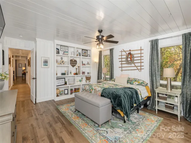 a spacious bedroom with a bed a couch and a chandelier