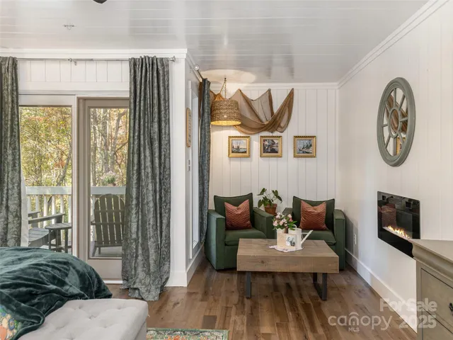 a living room with furniture a flat screen tv and a floor to ceiling window