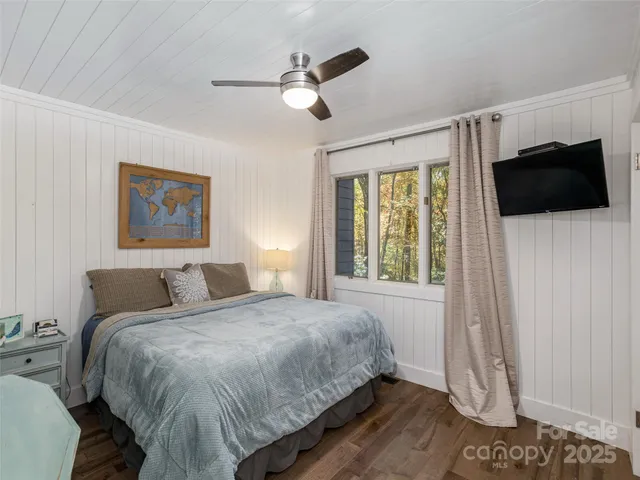 a bedroom with a bed a flat screen tv and a window