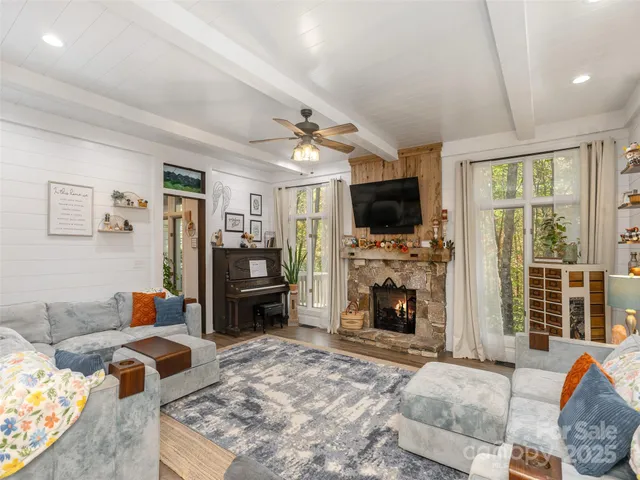 a living room with furniture a fireplace and a flat screen tv
