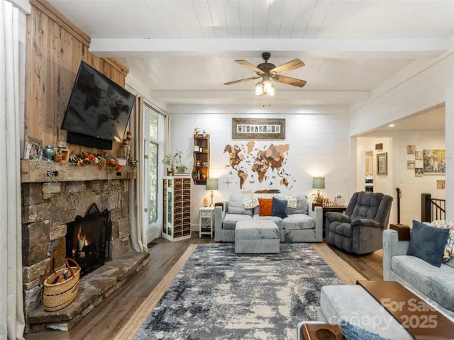 a living room with furniture a flat screen tv and a fireplace