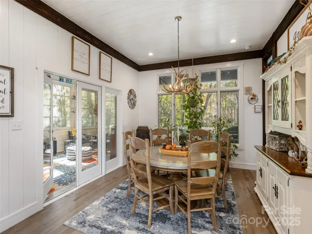 a dining room with furniture a chandelier and wooden floor