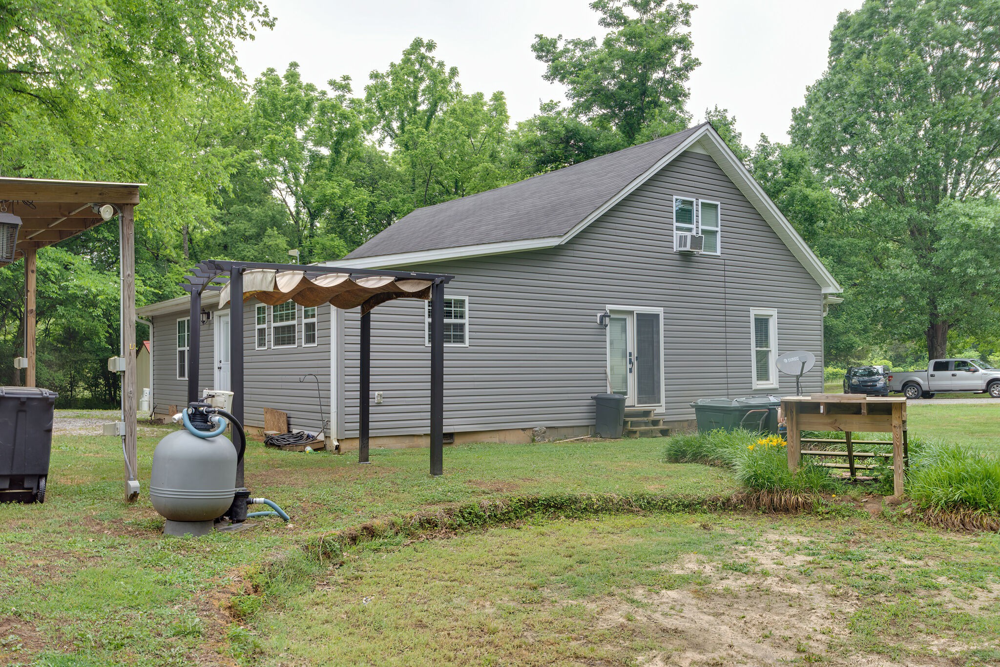 585 Shorts Road Pulaski, TN 38478 - Photo 29 of 32 a backyard of a house with table and chairs under an umbrella