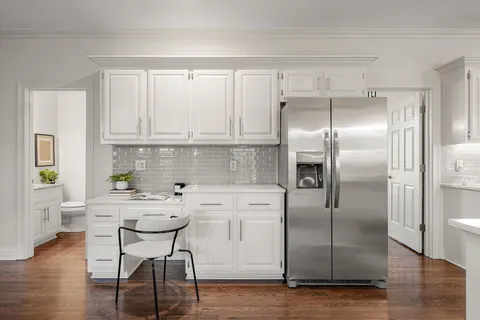 a kitchen with stainless steel appliances a refrigerator sink and white cabinets
