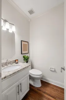 a bathroom with a granite countertop toilet and a sink