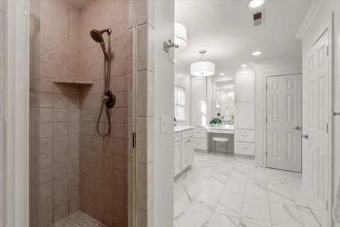a bathroom with a shower a sink a mirror and a shower