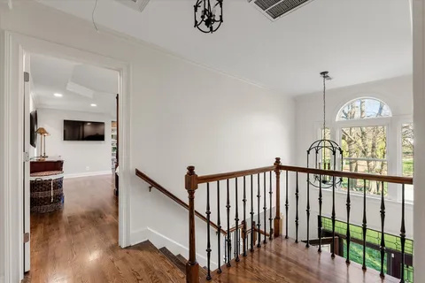 a view of a hallway with wooden floor windows and a kitchen view