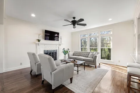a living room with furniture a flat screen tv and a fireplace
