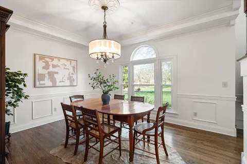 a view of a dining room with furniture a chandelier and wooden floor