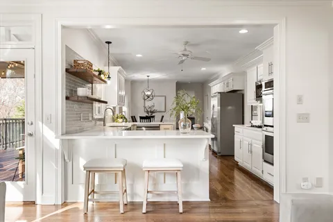 a large white kitchen with white cabinets and stainless steel appliances