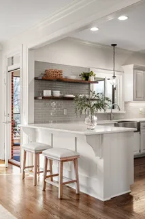 a kitchen with a table chairs stove and wooden floor