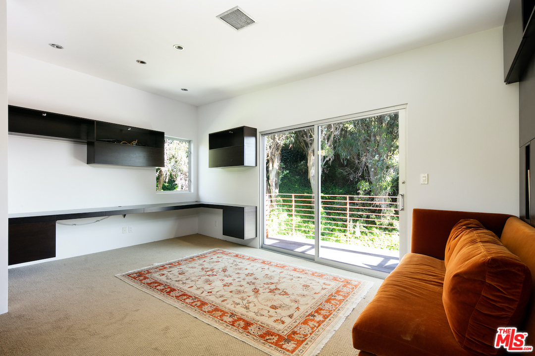 562 Stassi Lane Santa Monica, CA 90402 - Photo 19 of 33 a living room with furniture a flat screen tv and a large window