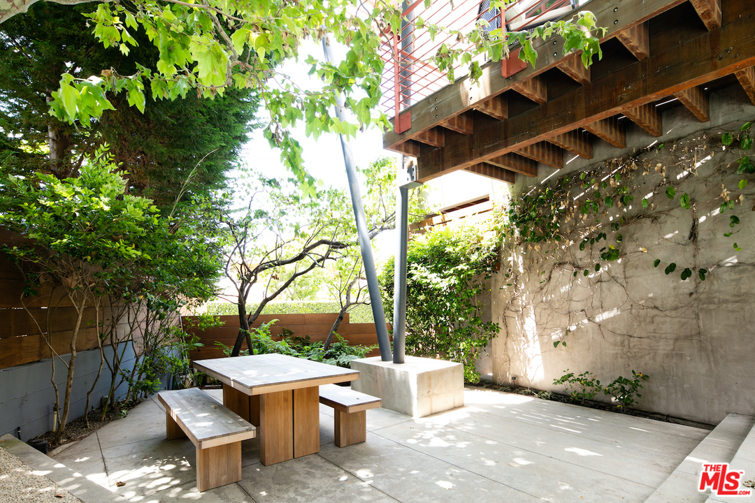 562 Stassi Lane Santa Monica, CA 90402 - Photo 27 of 33 a view of a patio with table and chairs and a large tree