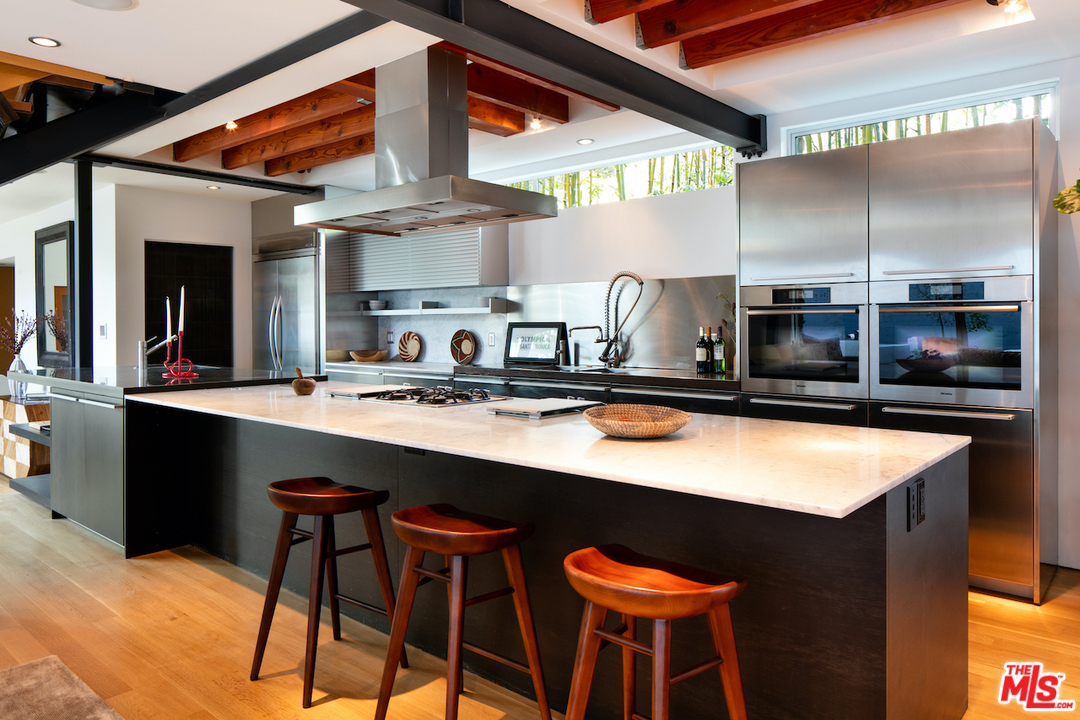 562 Stassi Lane Santa Monica, CA 90402 - Photo 6 of 33 a kitchen with stainless steel appliances kitchen island a table and chairs in it