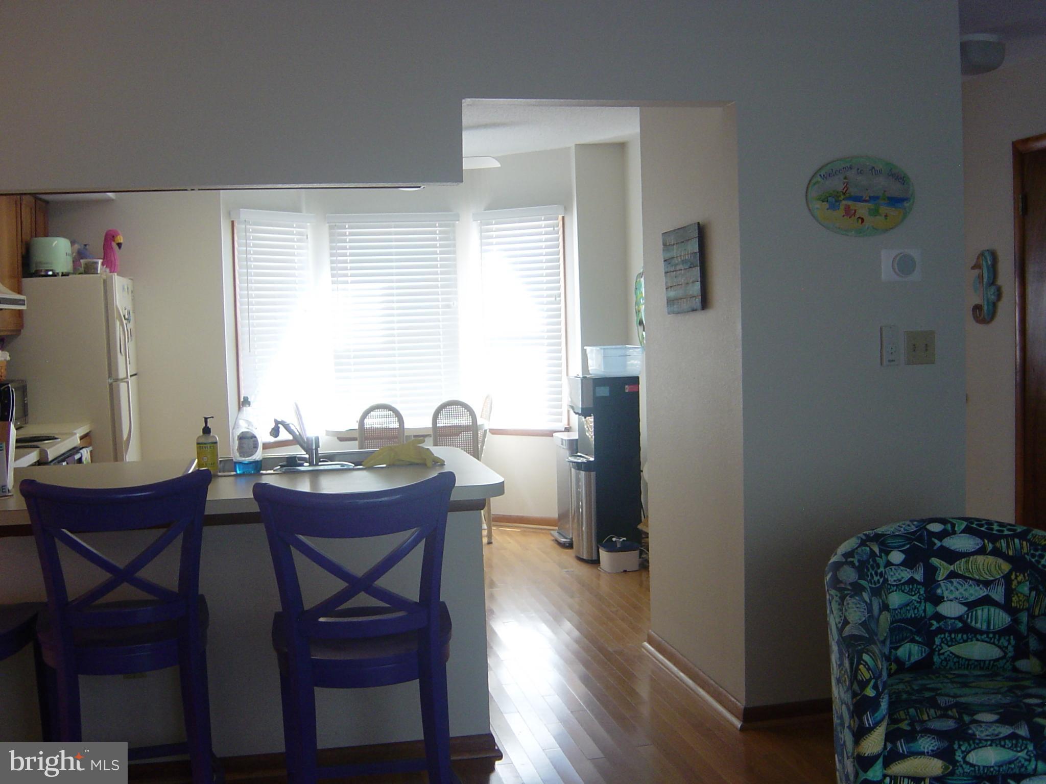 13609 Derrickson Avenue, Unit B Ocean City, MD 21842 - Photo 15 of 47 a view of a dining room with furniture and wooden floor