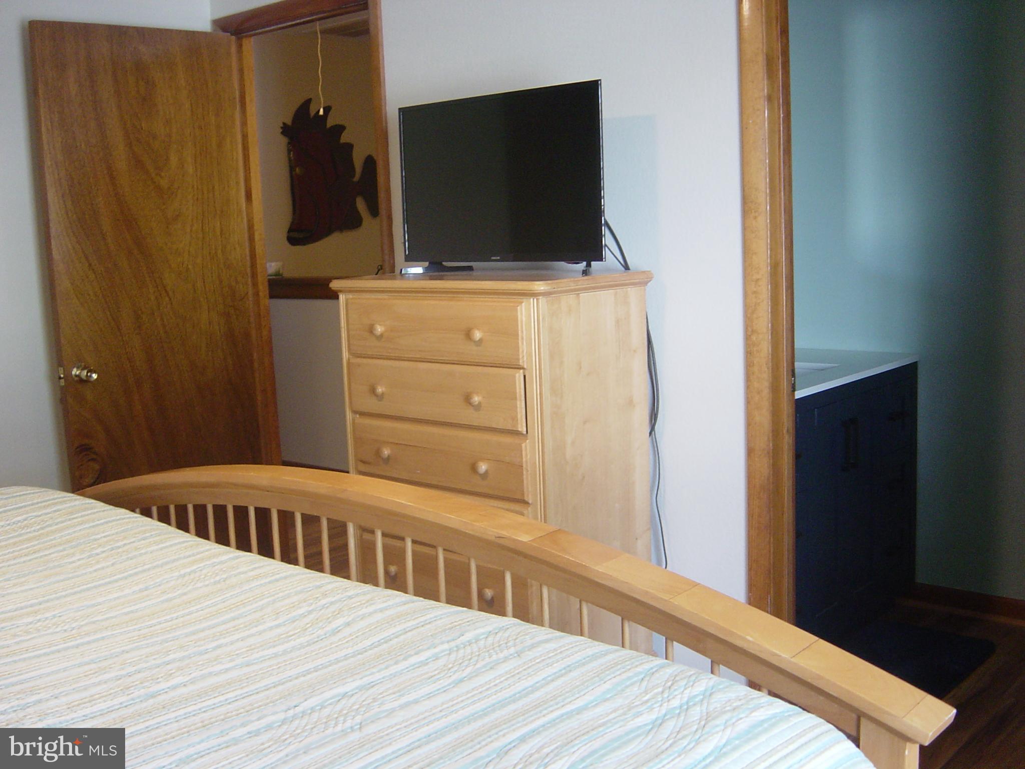13609 Derrickson Avenue, Unit B Ocean City, MD 21842 - Photo 29 of 47 a bedroom with a bed and flat screen tv