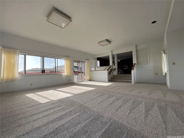 a view of an empty room with a window and fireplace