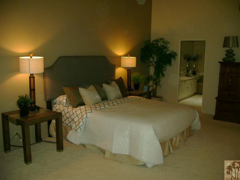 77950 Cherokee Road Indian Wells, CA 92210 - Photo 16 of 22 a bed sitting in a bedroom next to a lamp with a table and chair
