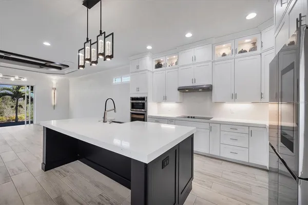 a kitchen with kitchen island stainless steel appliances a sink stove and refrigerator