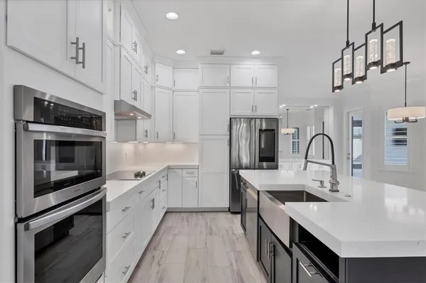 a kitchen with stainless steel appliances a sink stove and cabinets