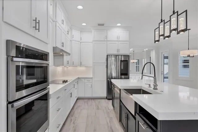a kitchen with stainless steel appliances a sink stove and cabinets