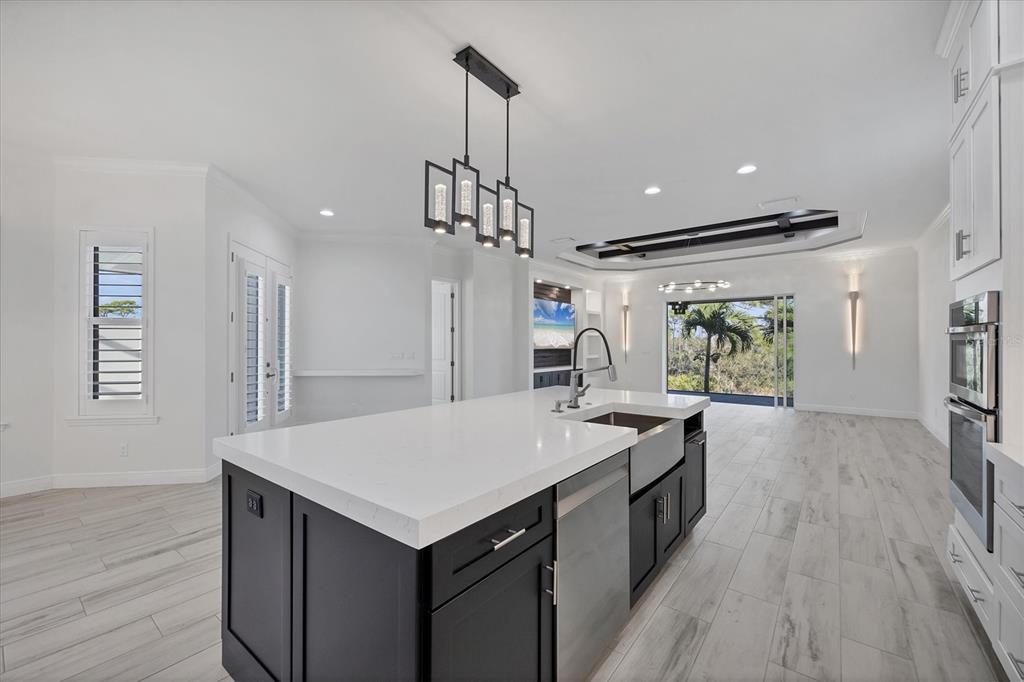8920 Conch Avenue Placida, FL 33946 - Photo 14 of 57 a kitchen with granite countertop a stove a sink a refrigerator and a wooden floor