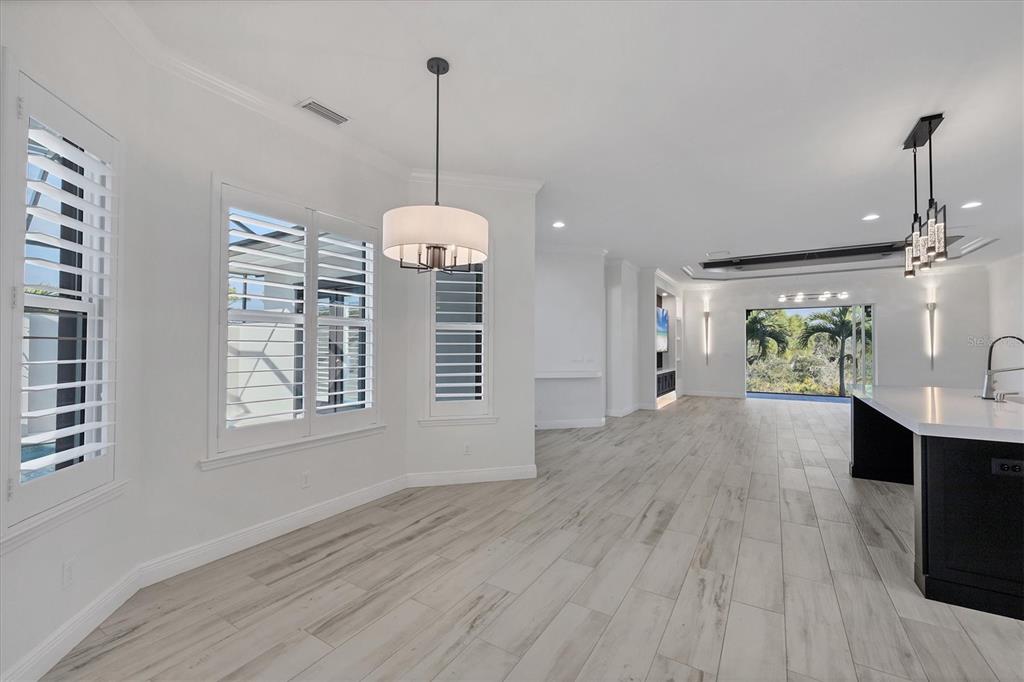 8920 Conch Avenue Placida, FL 33946 - Photo 16 of 57 a view of an empty room with wooden floor kitchen view and a window