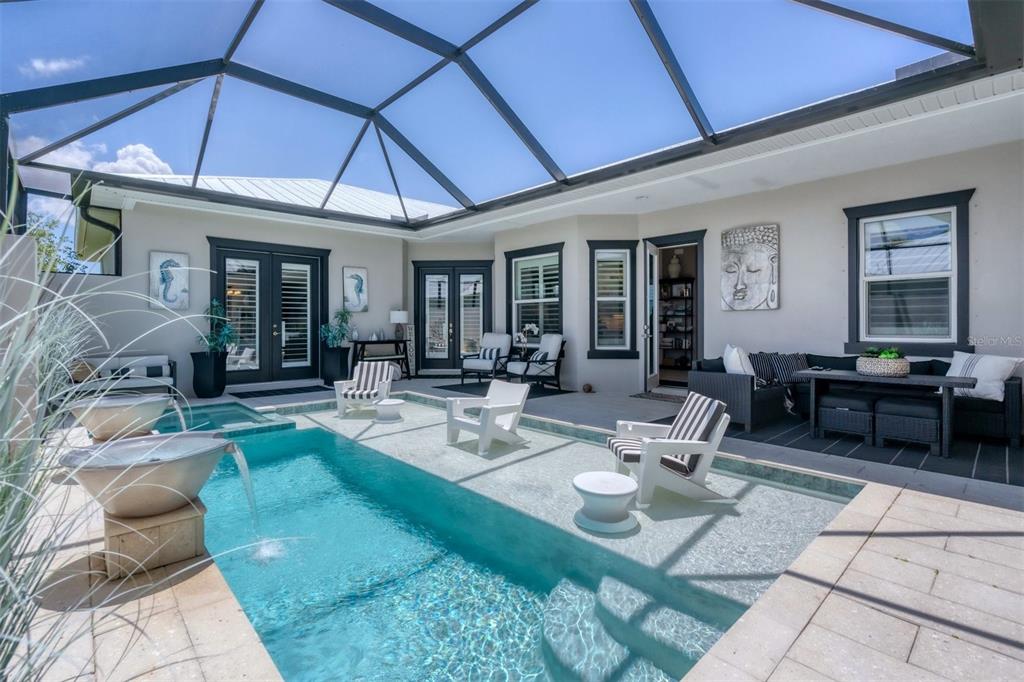 8920 Conch Avenue Placida, FL 33946 - Photo 31 of 57 a view of a patio with couches table and chairs under an umbrella