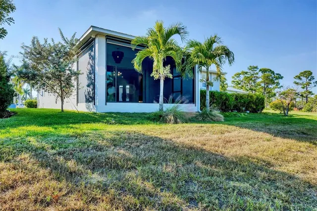 a view of a palm trees sitting in front of a house with a big yard