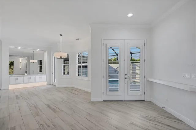 an empty room with wooden floor cabinet and windows