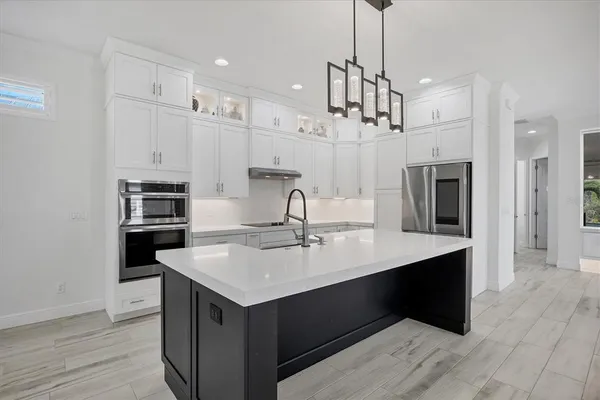 a kitchen with kitchen island a sink stainless steel appliances and cabinets