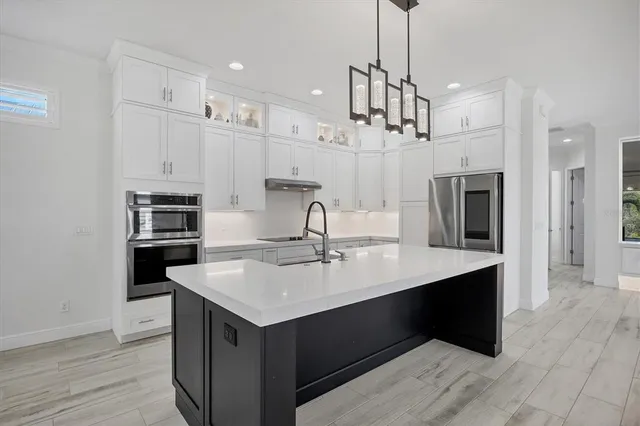 a kitchen with kitchen island a sink stainless steel appliances and cabinets