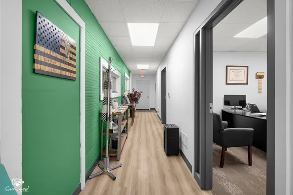 a view of a hallway with a livingroom and furniture
