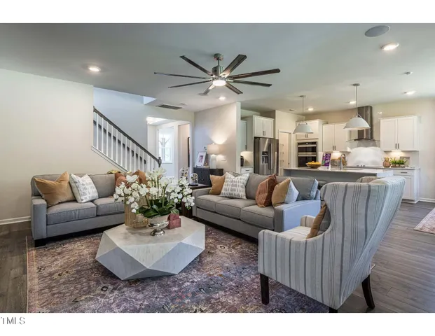 a living room with furniture a chandelier and a dining room