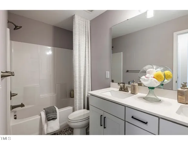 a bathroom with a granite countertop sink toilet a large mirror a shower and vanity