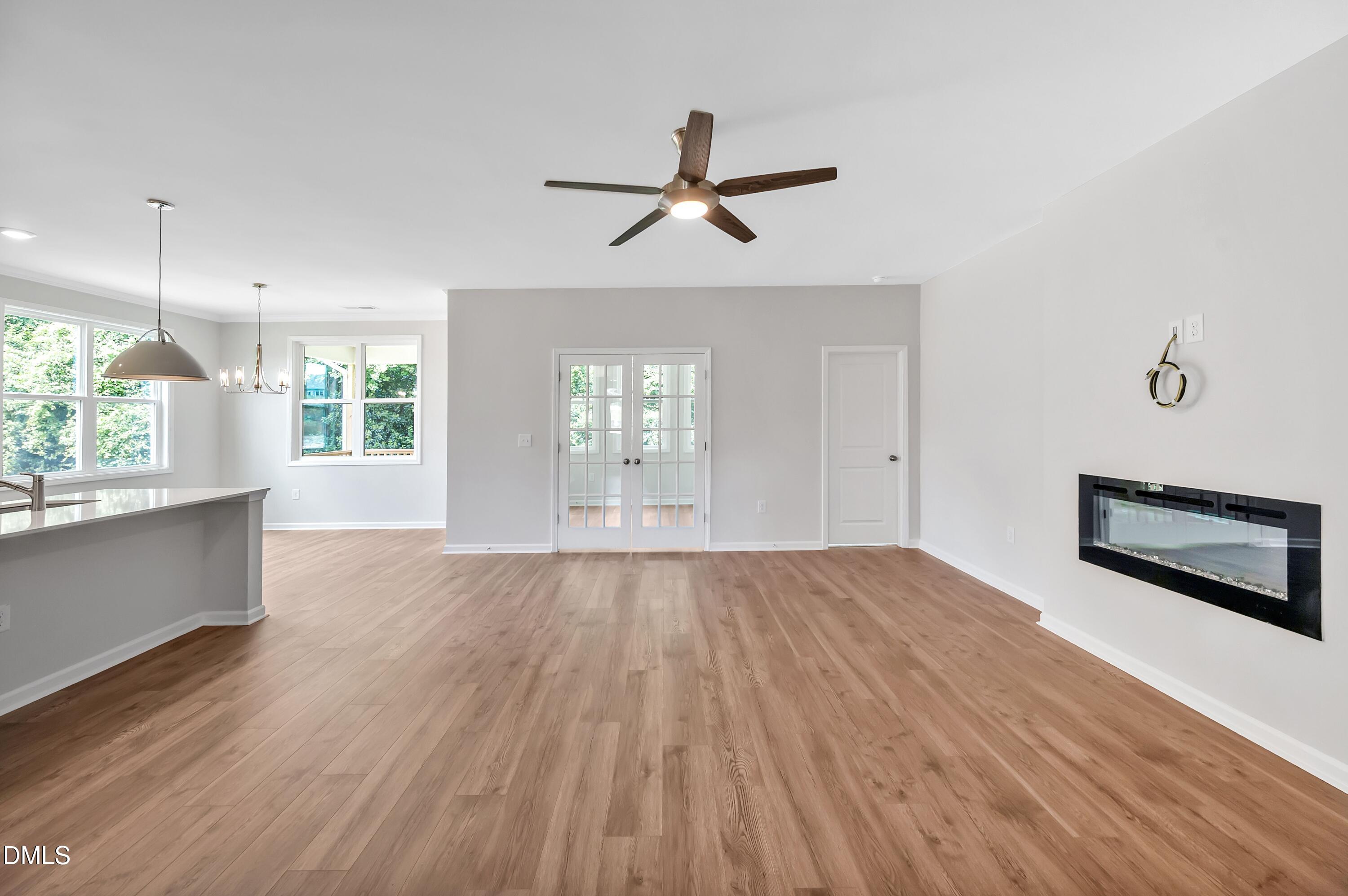 294 White Azalea Way Benson, NC 27504 - Photo 5 of 15 an empty room with wooden floor and windows
