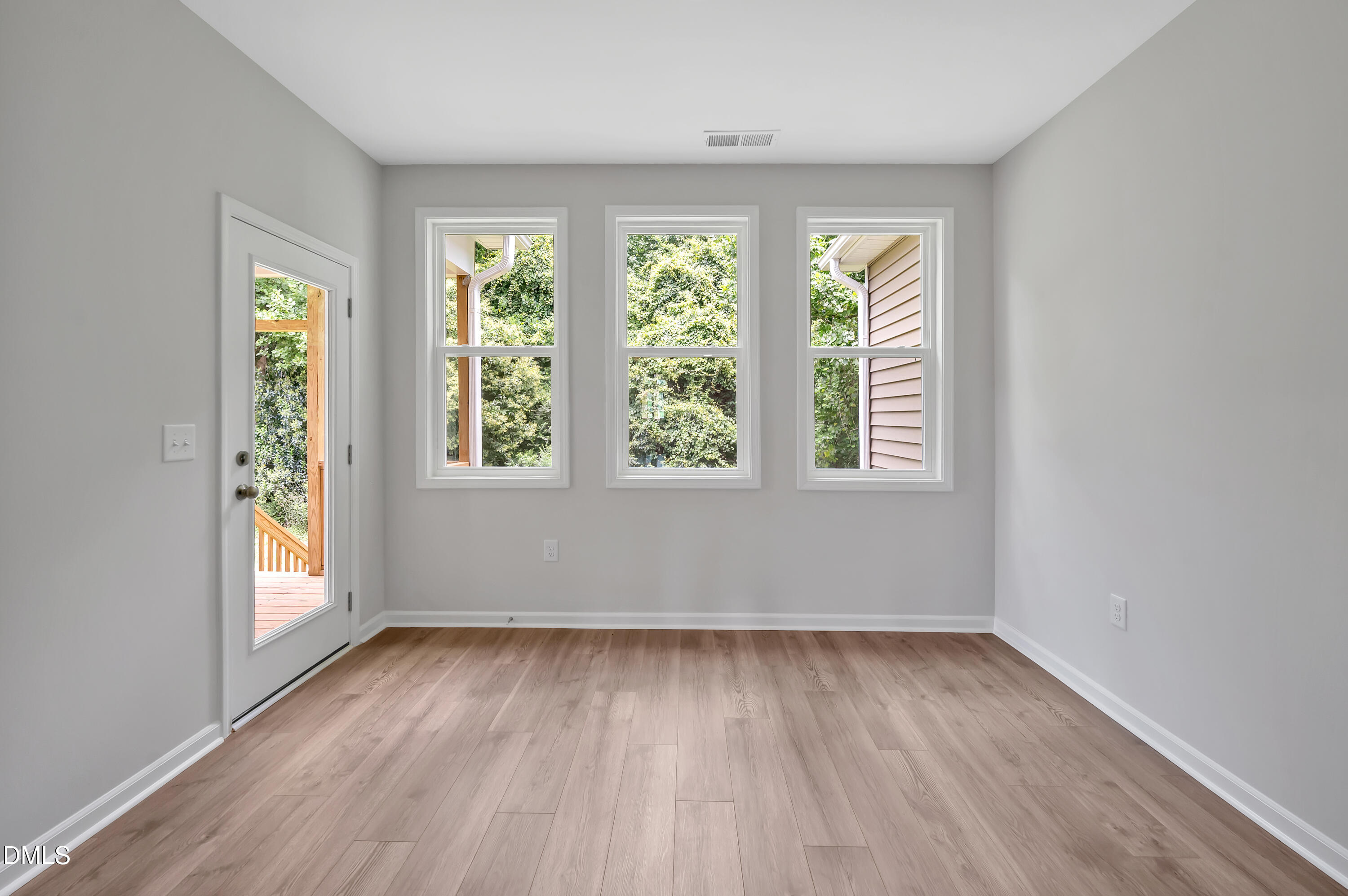 294 White Azalea Way Benson, NC 27504 - Photo 7 of 15 an empty room with wooden floor and windows