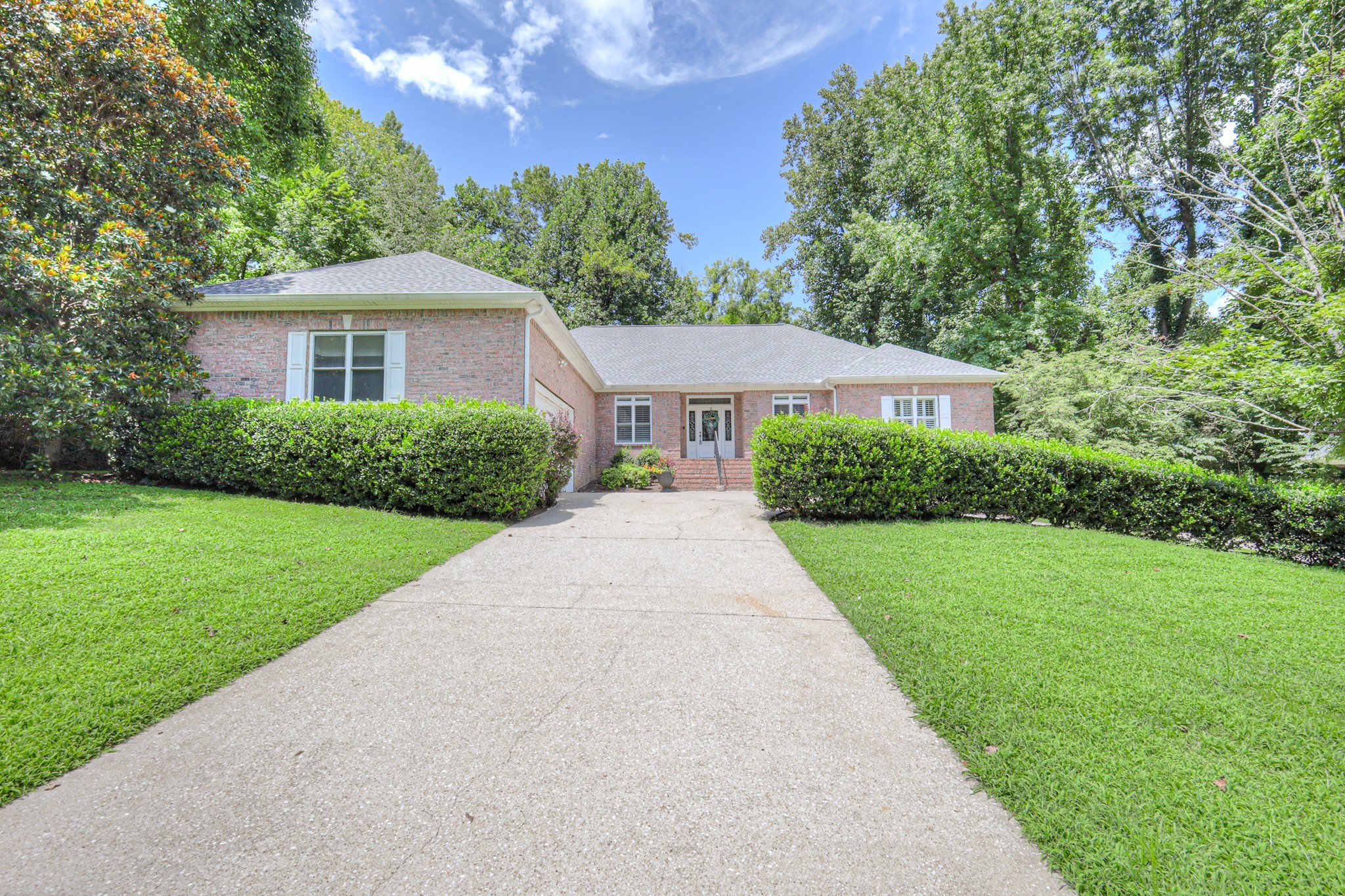 a front view of a house with yard and green space