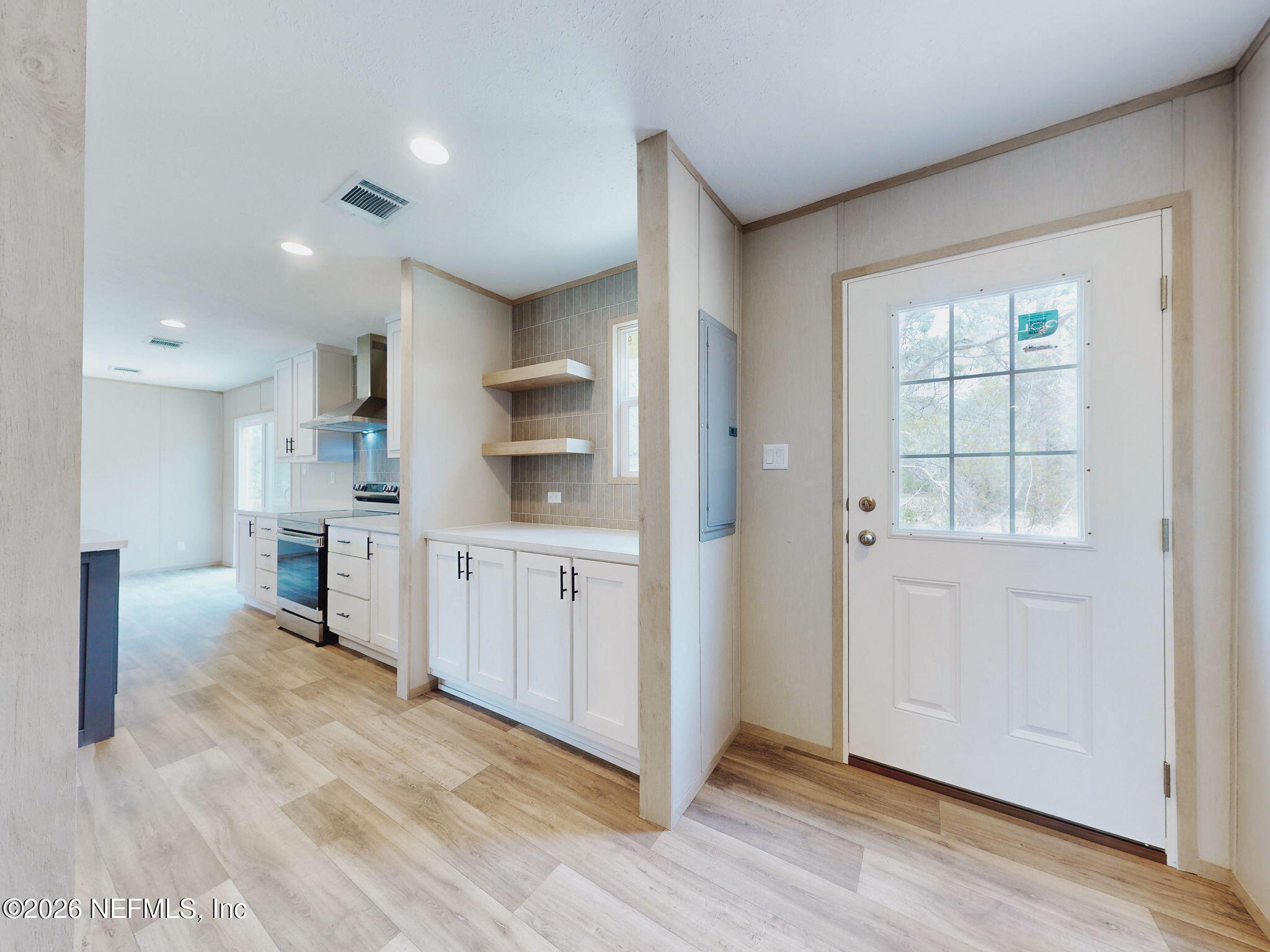 5784 County Road 214 Keystone Heights, FL 32656 - Photo 34 of 62 a kitchen with white cabinets and wooden floor