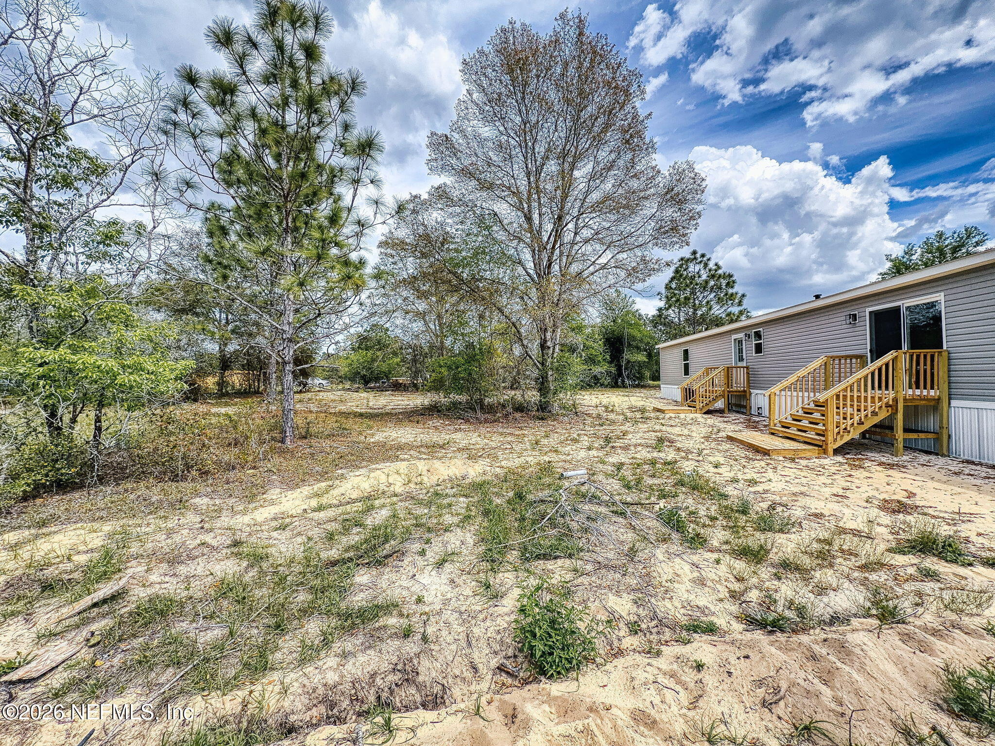 5784 County Road 214 Keystone Heights, FL 32656 - Photo 61 of 62 a backyard of a house with large trees and covered with wooden fence