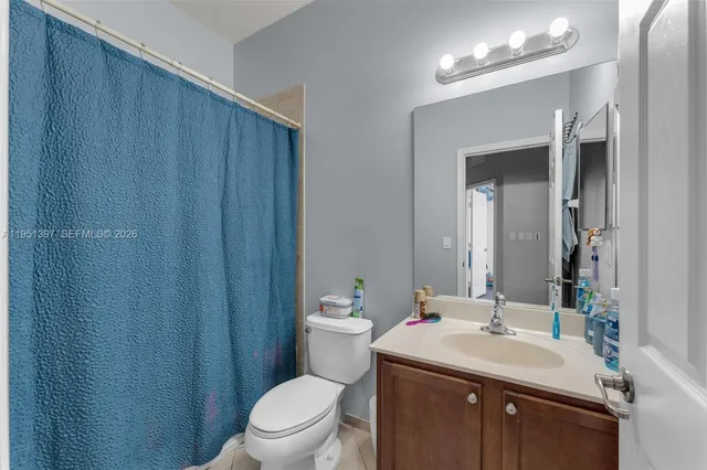 a bathroom with a sink vanity mirror and toilet