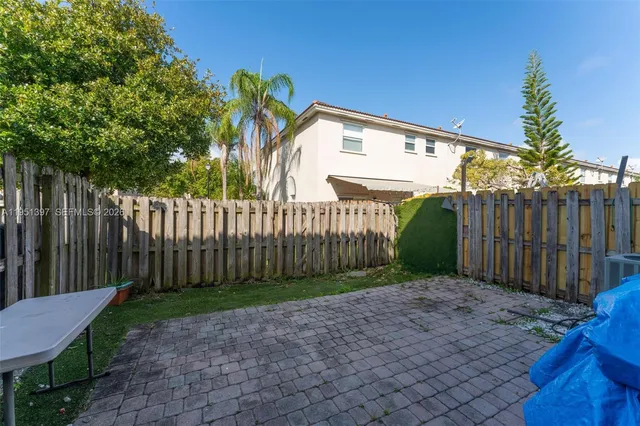 a view of a backyard with wooden fence