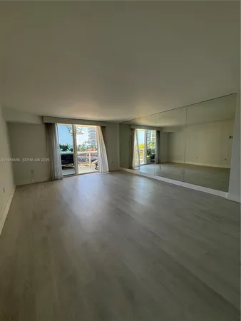 an empty room with projector and wooden floor