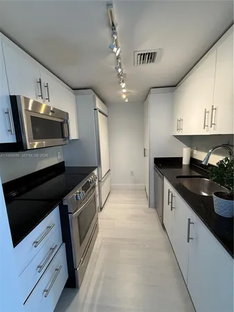 a large kitchen with a stove and a sink