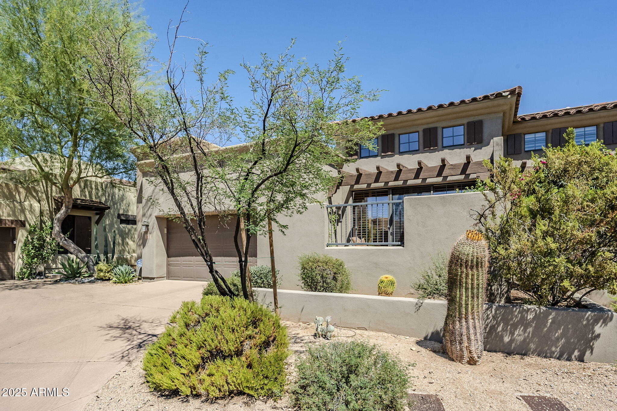 9270 East Thompson Peak Parkway, Unit 342 Scottsdale, AZ 85255 - Photo 2 of 40 a front view of a house with a yard and fountain in middle