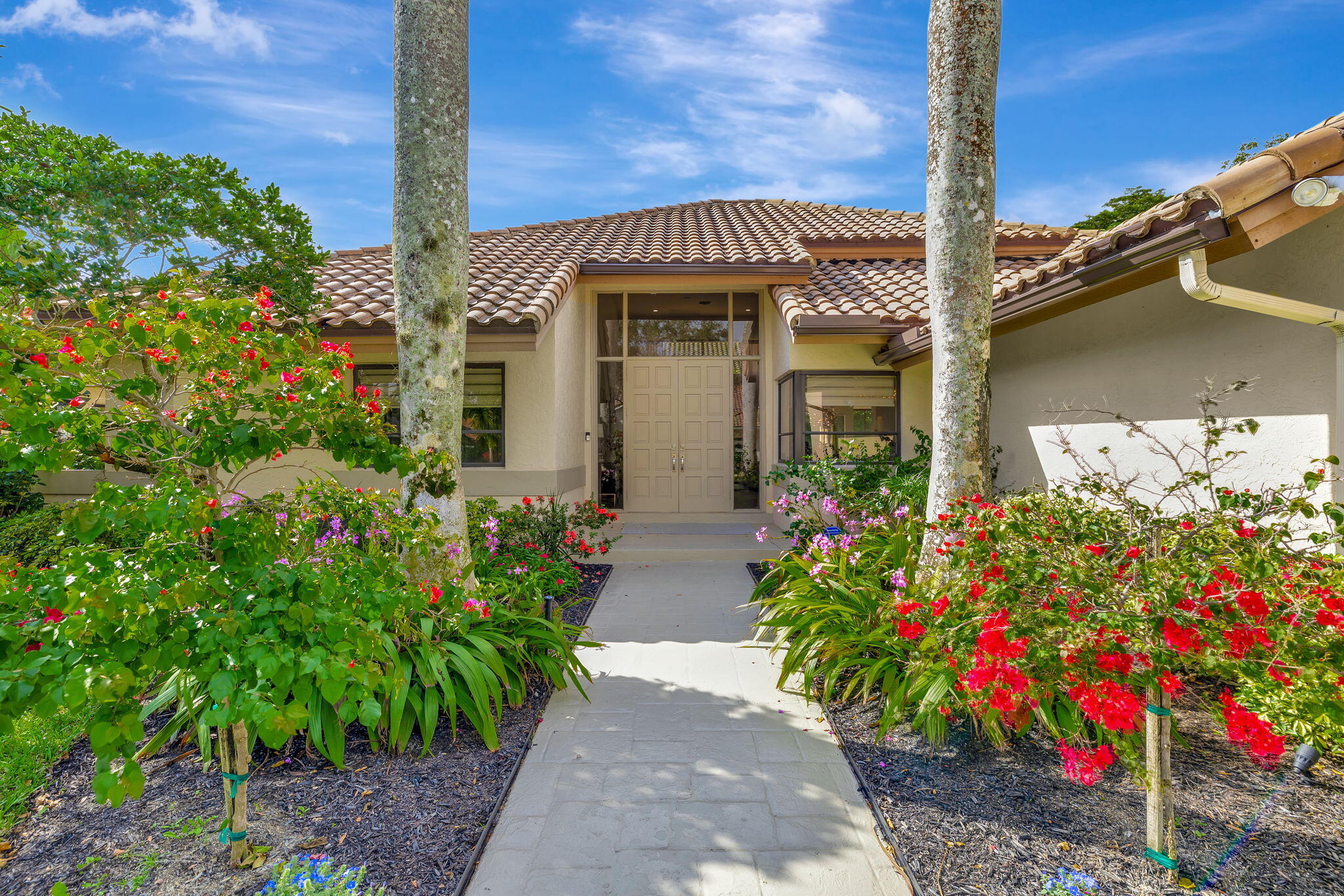 a front view of a house with lots of flower plants