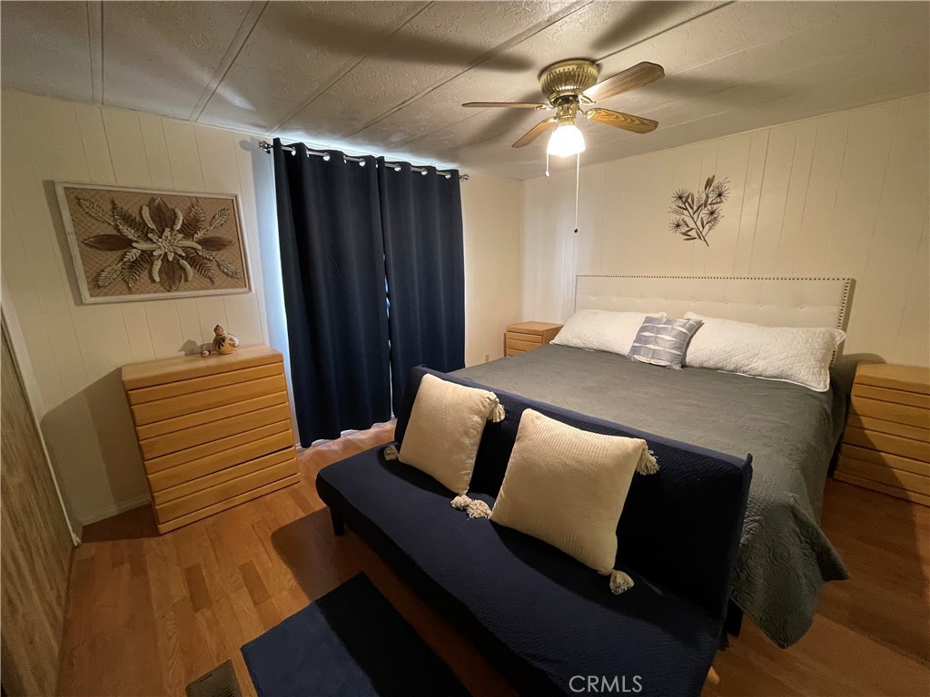 74711 Dillon Road, Unit 411 Desert Hot Springs, CA 92241 - Photo 12 of 26 a bedroom with a bed and wooden floor