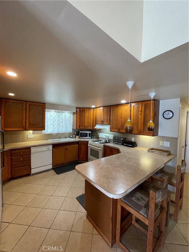 74711 Dillon Road, Unit 411 Desert Hot Springs, CA 92241 - Photo 5 of 26 a kitchen with stainless steel appliances kitchen island granite countertop a sink a counter space and cabinets