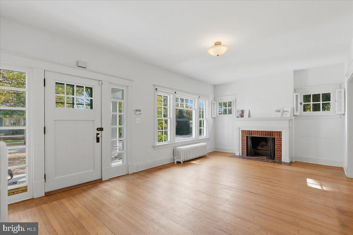 5900 32nd Street Northwest Washington, DC 20015 - Photo 8 of 51 an empty room with windows a fireplace and wooden floor